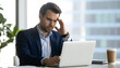 © Asmat - Confused Young Businessman Working On Laptop At Office Desk Looking Frustrated