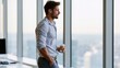 © AZ Studio - Man in casual office attire holding coffee cup and looking out large window