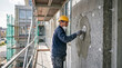 © Arra Vais - Worker applies wall insulation plaster to building facade. Craftsman smooths wet coating over thermal panels, ensuring durable wall insulation plaster.
