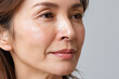 © JoeyMarut - Close up portrait of middle aged Japanese woman with natural skin texture and subtle smile, soft lighting highlighting fine lines and healthy glow