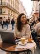 © Moon & Co - Happy Brunette Woman Laughing Heartily While Working on Laptop at Outdoor Paris Café Terrace