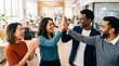 © Eve - Joyful diverse creative team celebrating success with high five at modern bright open space office. Happy multiethnic corporate colleagues cheering, laughing, enjoying teamwork triumph.