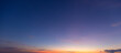 © banjongseal324 - Vibrant Sunset Sky with Colorful Clouds,A breathtaking view of the twilight sky featuring a gradient of deep blue transitioning into warm golden and orange hues with soft cloud formations, perfect for