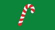 © Bagas - A red and white striped candy cane stands upright against a solid green background