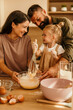© La Famiglia - Family baking together at home mixing dough