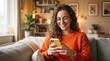 © MDBadrul - Young woman with curly hair smiling while using a smartphone at home