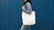 © Ruby - Side profile of woman wearing denim jacket carrying a blank white canvas tote bag