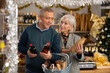© JackF - Elderly husband and wife choosing wine and whiskey for Christmas celebration at supermarket