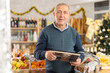 © JackF - Elderly man buyer chooses dried fruits in christmas decorated grocery store