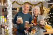 © JackF - Portrait of happy elderly couple with sweet products in supermarket - nougat, panettone, marzipan, panellets