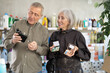 © JackF - When choosing and properties, mature couple gets acquainted with perfume and pallet of make up cosmetic new products assortment. Client compares products from different manufacturers