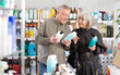 © JackF - Elderly couple stands near the shelves with goods in the household department of a supermarket and chooses a care shampoo for gray hair and a moisturizing shower gel
