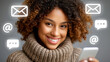 © ArtShop - Young black woman smiling while using smartphone in cozy sweater