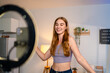 © Kawee - Caucasian woman content creator recording video on mobile phone in house.