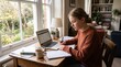 © _KUBE_ - Teenage girl studies at home with a laptop and notebooks near a bright window. The peaceful workspace reflects independent learning and modern education.