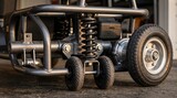 Detailed view of a go-kart's suspension and wheels highlighting the robust construction and mechanical design in a garage setting during late afternoon.