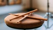 © Burhan - Crossed wooden drumsticks resting on a textured round stool