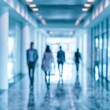 © Anastasiia - Blurred figures walk through a modern hallway with large windows during the day
