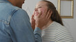 © Krakenimages.com - Man cups woman's face with hands, woman smiling and laughing as the couple leans close in building; affection intimacy joy.