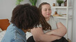 © Krakenimages.com - Woman seated on bed with arms crossed and bare forearms visible, looking away while man reaches to her knee and speaks beside shelving in bedroom; relationship tension.