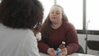 © Krakenimages.com - Woman patient listens while doctor in white coat holds a medicine bottle and the patient's hand rests on the table in a clinic building; concern care.