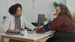 © Krakenimages.com - Doctor measures woman's blood pressure with cuff and stethoscope while patient holds out arm in clinic building; reassurance trust.