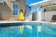 © ADDICTIVE STOCK - Woman in yellow dress beside stone building