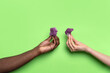 © ADDICTIVE STOCK - Multiethnic hands holding purple cauliflower on green