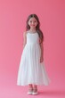 © Yevheniia Kudrova - Happy girl in a white dress on a pink background with space for text, vertical