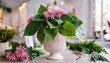 © Ariel - large green hosta leaves and pink asters sit inside white stone urn on table with floral supplies floral design class diy flower arranging floristry workshop creative education