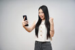 © Ibenk.88 - Young Indonesian Woman Celebrating Success with Smartphone