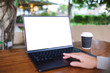 © Farknot Architect - Mockup image of a woman working and touching on laptop computer touchpad with blank white desktop screen in cafe