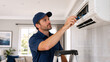 © Vyatcheslav - Professional technician on ladder repairing indoor air conditioning unit. Male worker in blue uniform servicing wall mounted split system. HVAC maintenance in residential home