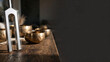 © Dezayn - Sound Healing Therapy Session with Tuning Fork and Tibetan Singing Bowls on a Wooden Table Against a Dark Background