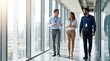 © betania - Diverse Group of Business Professionals Walking and Discussing in Modern Corporate Office Hallway
