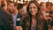 © AndiAzis - Joyful woman with long wavy brown hair smiling at outdoor evening event