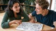 © AndiAzis - Young adult couple sharing a coloring book at a light wood table in a cozy room