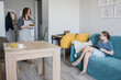 © artmim - Smiling child girl using a tablet gadget while her mother does housework at home