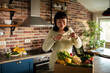 © Davor - Woman photographing fresh produce box in home kitchen