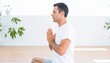 © Salam - Man in white shirt meditating indoors with plants.