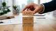 © Zaidi - Hand stacking wooden blocks with words LAND VALUE HOME