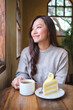 © Farknot Architect - Vertical portrait image of a woman drinking coffee and eating a lemon cake in cafe