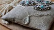 © Bussakon - A collection of silver jewelry featuring teardrop and oval mother of pearl pendants resting on a textured linen cushion