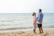 © SKW - Happy Senior Asian Couple Dancing Joyfully on the Beach, Retirement Travel Lifestyle