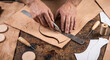 © starush - Leatherworker Hands Trimming Vegetable-Tanned Hide on Scuffed Bench