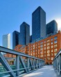 © Georgii - Dynamic urban scene with glass skyscrapers, brick office building and pedestrian bridge in blue light