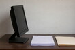 © AiPhoto - 暗い画面の汎用モニターと白紙書類の業務イメージ
