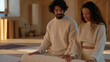 © AnastasiiaRozhmanova - Couple dynamic, a husband and wife reiki practitioners setting up a December group wellness retreat space together, arranging floor mats in a minimalist studio, year end stress