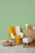 © Pixel-Shot - Autumn interior of living room with white armchair, lamp, pumpkins and chest of drawers