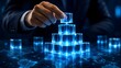 © D' Architect - Global business expansion concept showing executive hands placing the final glowing blue block on a digital pyramid over a world network map representing international corporate connections.